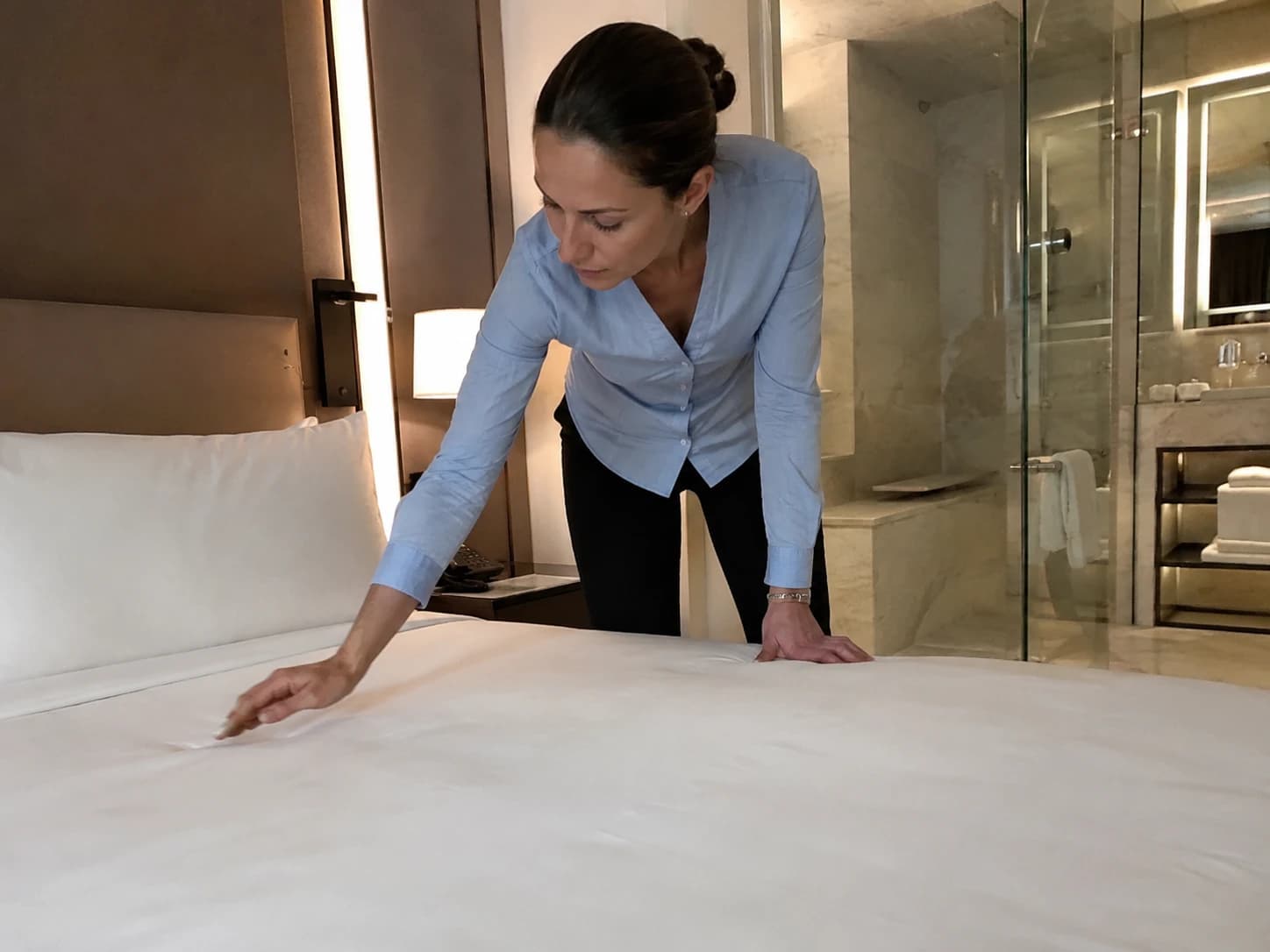 Voyageur inspectant la propreté d'une chambre d'hôtel, illustration de la montée des exigences clients en hôtellerie en 2026