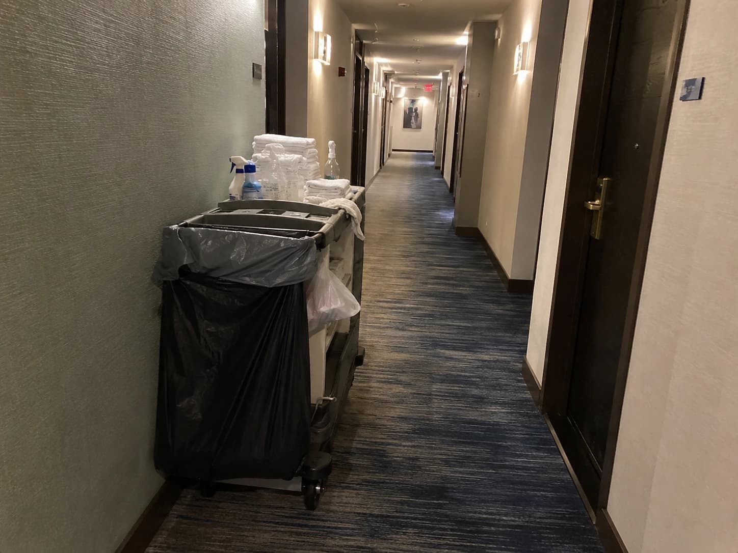 Chariot de ménage abandonné dans un couloir d'hôtel vide, symbolisant le turnover et le départ des femmes de chambre en hôtellerie